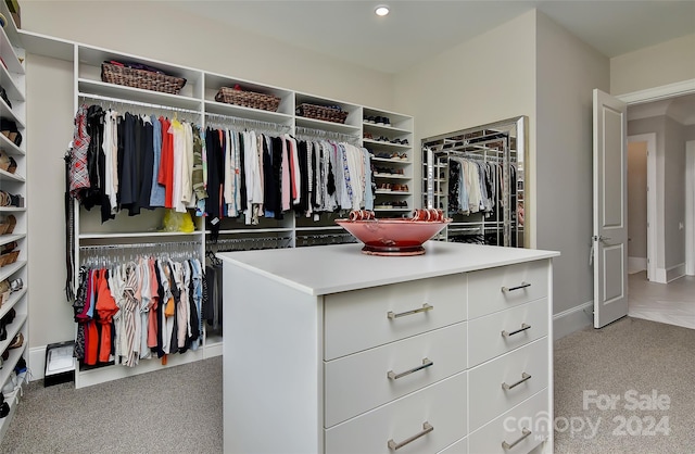 walk in closet featuring light colored carpet