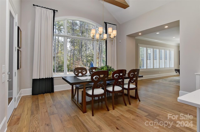 dining room with vaulted ceiling, an inviting chandelier, light hardwood / wood-style flooring, and plenty of natural light