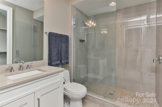 bathroom with toilet, vanity, and walk in shower