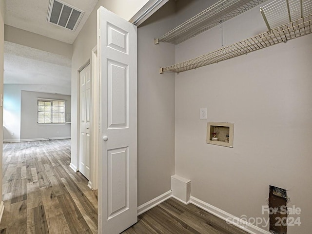 clothes washing area with dark hardwood / wood-style floors, a textured ceiling, and hookup for a washing machine