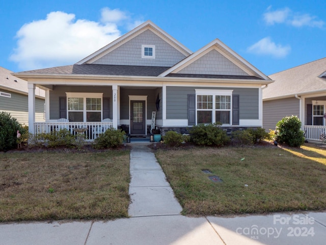 view of front of house with a front yard and covered porch