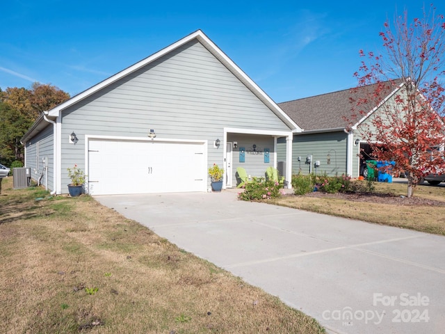 view of front of property featuring central AC unit, a garage, and a front yard