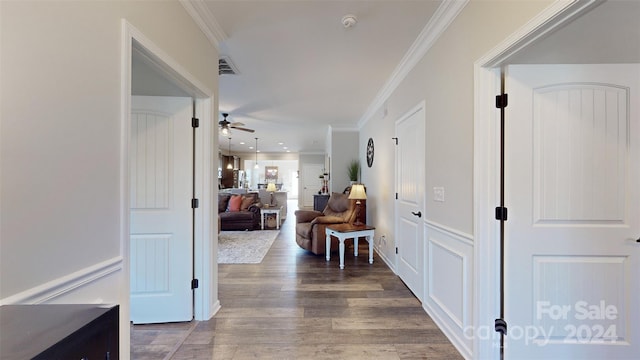 corridor with ornamental molding and hardwood / wood-style flooring