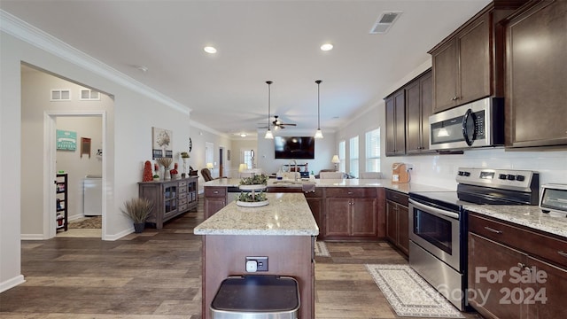 kitchen with kitchen peninsula, appliances with stainless steel finishes, dark hardwood / wood-style flooring, and ornamental molding