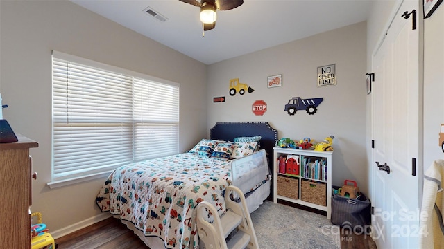 bedroom featuring hardwood / wood-style flooring, ceiling fan, and a closet