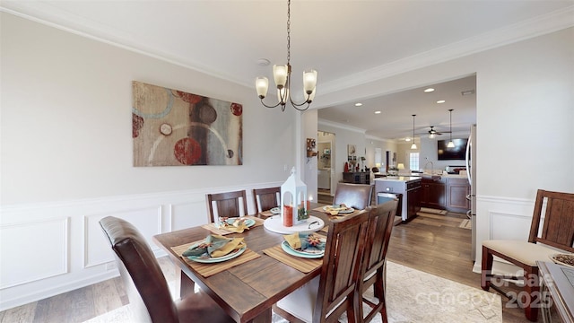 280 Kerri Dawn Ln, Locust, NC 28097 - dining space with a chandelier, crown molding, a decorative wall, light wood-style flooring, and a wainscoted wall