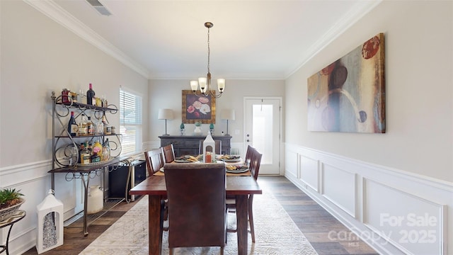 280 Kerri Dawn Ln, Locust, NC 28097 - dining room featuring ornamental molding, plenty of natural light, a chandelier, dark wood-style flooring, and a decorative wall