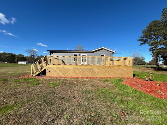 rear view of house featuring a yard and a deck