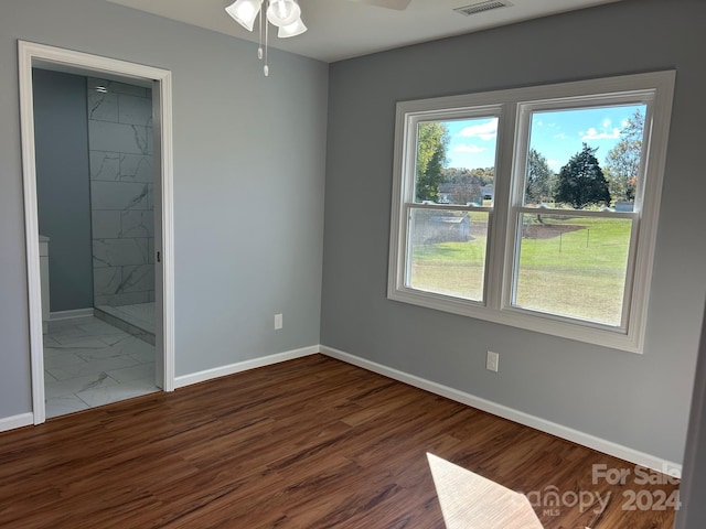 unfurnished bedroom featuring dark hardwood / wood-style flooring, ensuite bathroom, and ceiling fan