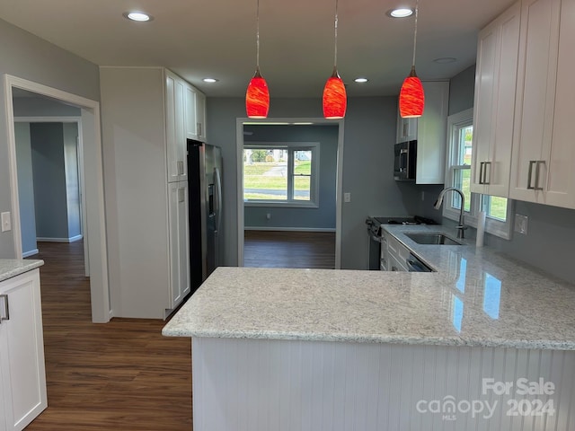 kitchen with kitchen peninsula, pendant lighting, white cabinetry, and sink