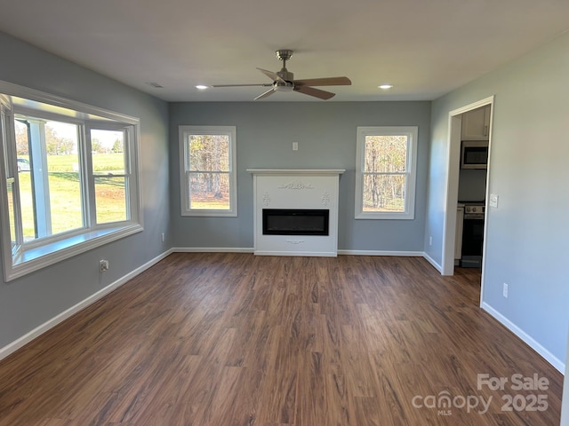 3596 Bethany Church Rd, Claremont, NC 28610 - unfurnished living room featuring a ceiling fan, baseboards, dark wood finished floors, a glass covered fireplace, and recessed lighting