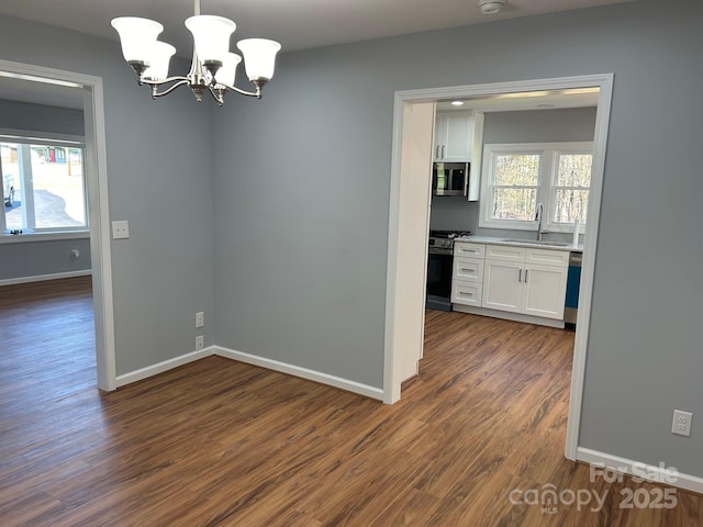 3596 Bethany Church Rd, Claremont, NC 28610 - unfurnished room featuring dark wood-style floors, a sink, baseboards, a chandelier, and a smoke detector