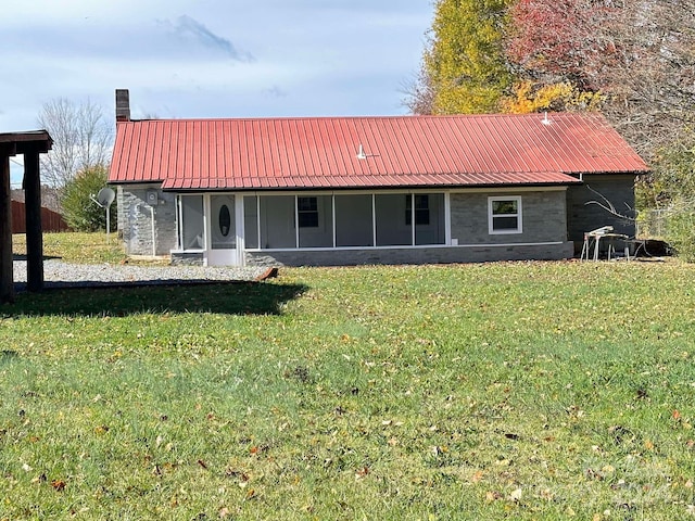 view of front facade with a sunroom and a front yard