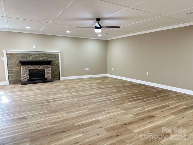 unfurnished living room with a paneled ceiling, ceiling fan, light hardwood / wood-style floors, and a fireplace