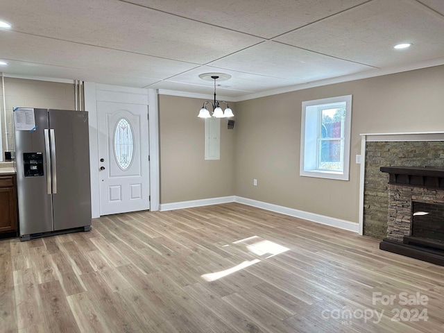 interior space featuring crown molding, a fireplace, and light hardwood / wood-style floors