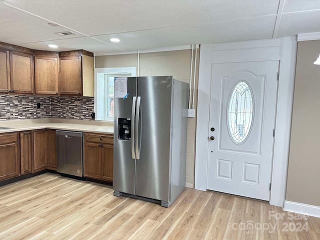 kitchen with stainless steel appliances, tasteful backsplash, and light hardwood / wood-style floors