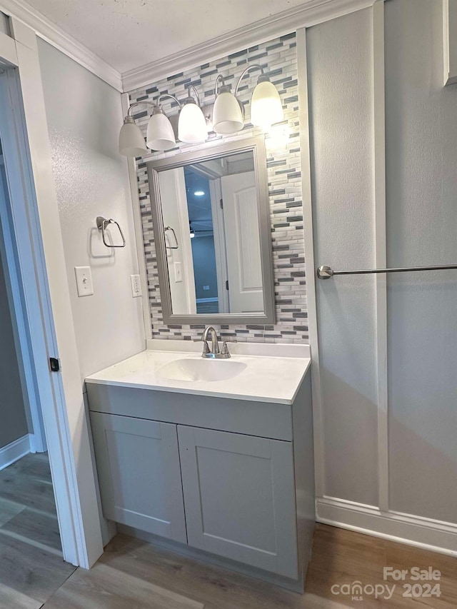 bathroom with crown molding, wood-type flooring, and backsplash