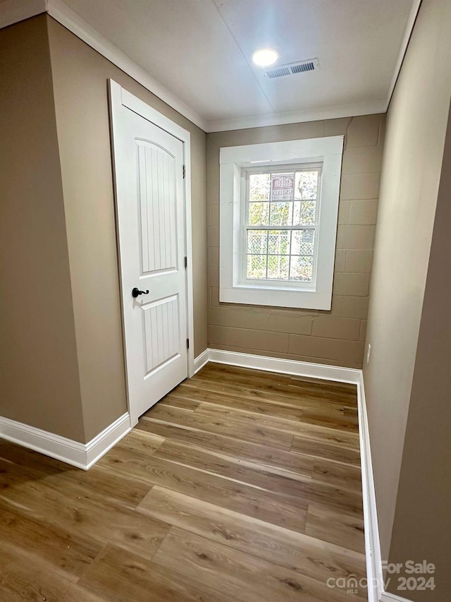 interior space with light hardwood / wood-style flooring and crown molding