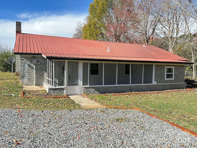 exterior space featuring a sunroom and a yard