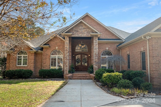 view of front of property featuring a front yard and french doors