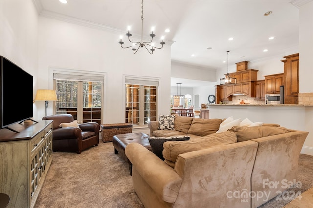 carpeted living room featuring ornamental molding and a notable chandelier