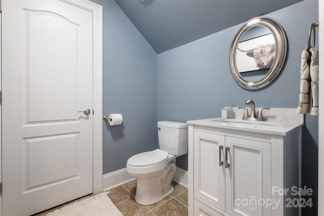 bathroom featuring tile patterned floors, vanity, toilet, and lofted ceiling