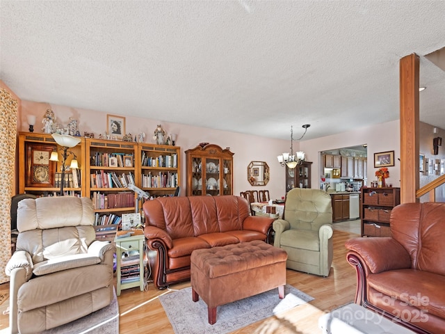 living room with a textured ceiling, light hardwood / wood-style floors, and a notable chandelier