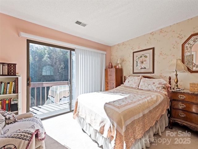 carpeted bedroom with access to exterior and a textured ceiling