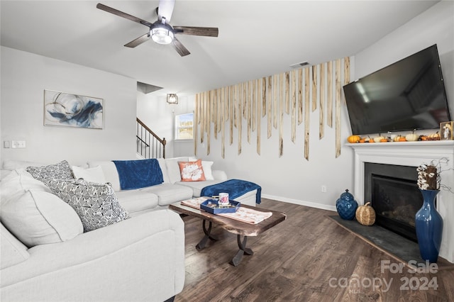 living room with dark hardwood / wood-style flooring and ceiling fan