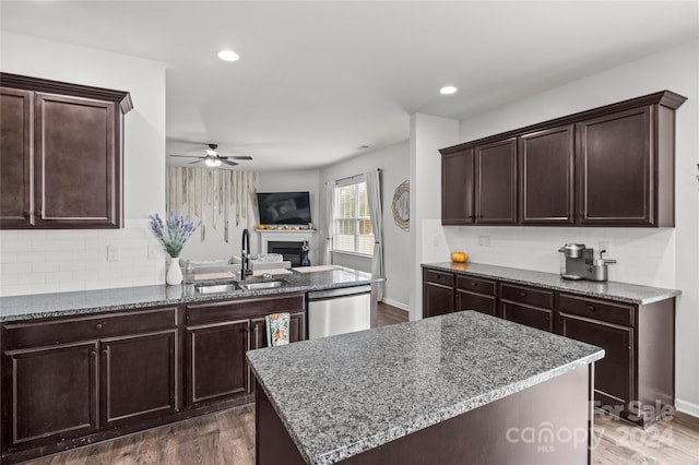 kitchen with dishwasher, dark hardwood / wood-style flooring, a kitchen island, and sink