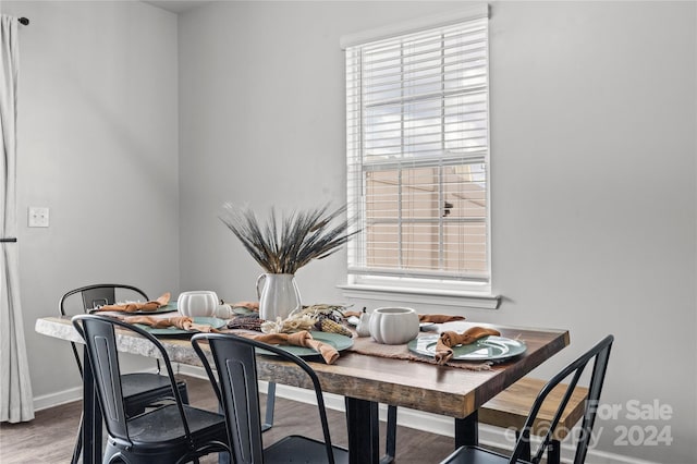 dining area featuring wood-type flooring and a healthy amount of sunlight