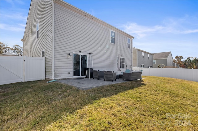 back of property featuring a lawn, a patio area, and an outdoor hangout area