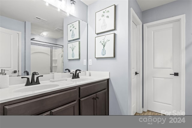 bathroom featuring vanity and a shower with shower door