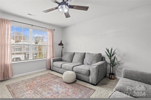 carpeted living room with ceiling fan