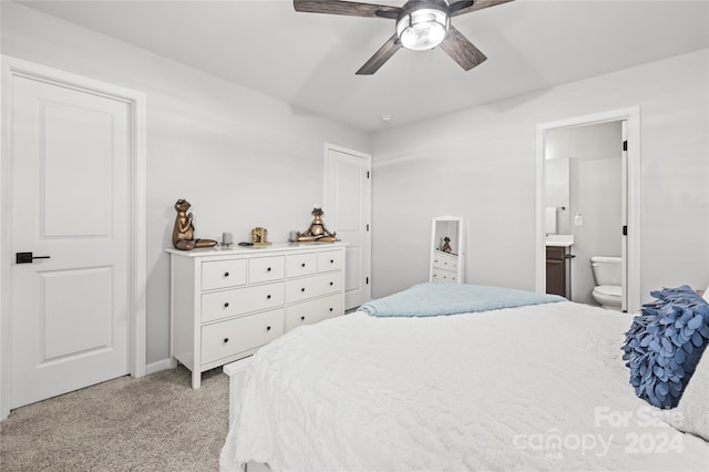 bedroom with light carpet, ensuite bathroom, and ceiling fan