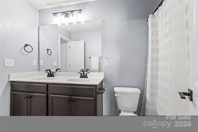 bathroom featuring vanity, a shower with shower curtain, and toilet