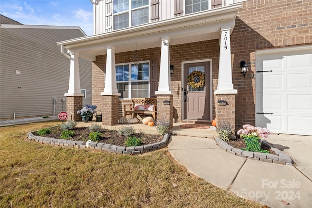 doorway to property with a porch and a garage