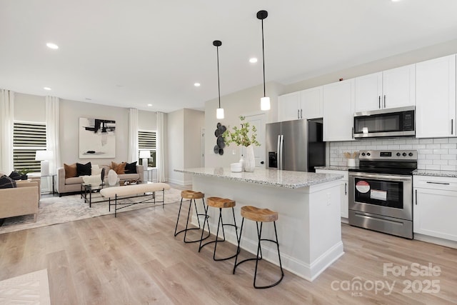 kitchen featuring a kitchen island, white cabinetry, and appliances with stainless steel finishes