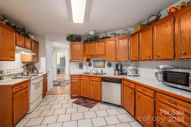 kitchen with tile counters, sink, a textured ceiling, and appliances with stainless steel finishes