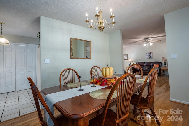 dining space featuring ceiling fan with notable chandelier, wood-type flooring, and a textured ceiling