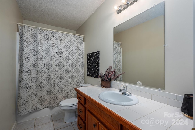 bathroom featuring vanity, tile patterned floors, a textured ceiling, and toilet