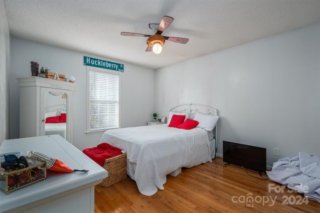 bedroom featuring ceiling fan, a textured ceiling, and hardwood / wood-style flooring