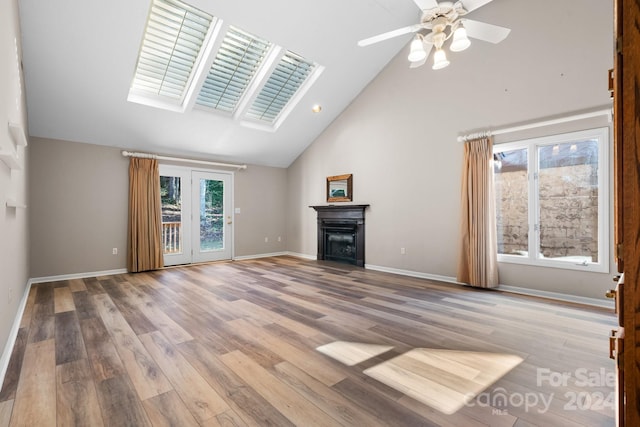 unfurnished living room with ceiling fan, high vaulted ceiling, and light wood-type flooring