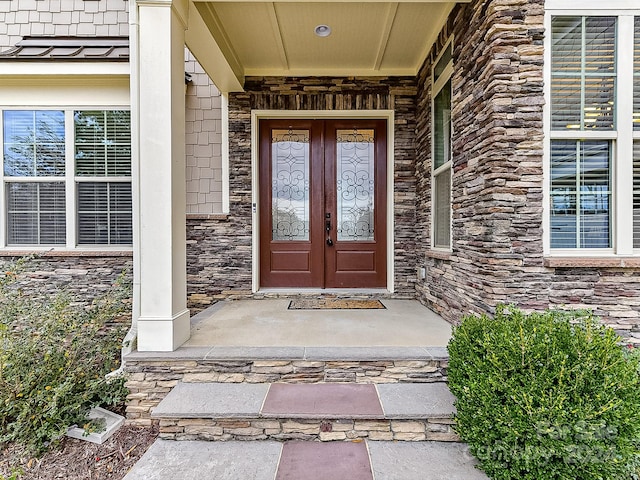 doorway to property featuring covered porch and french doors