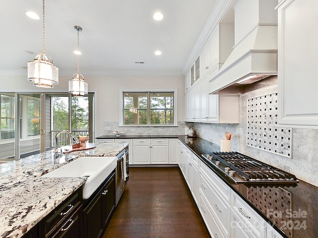 kitchen featuring white cabinets, dark stone counters, and sink