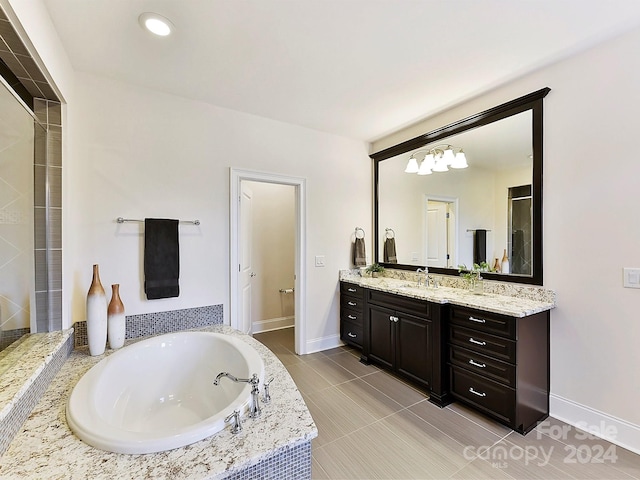 bathroom featuring vanity, tile patterned floors, and tiled tub