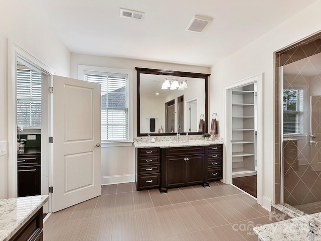 bathroom featuring tile patterned floors, vanity, and tiled shower