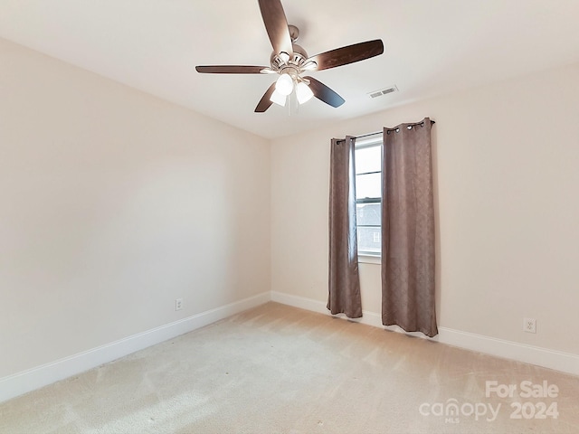 carpeted spare room with ceiling fan