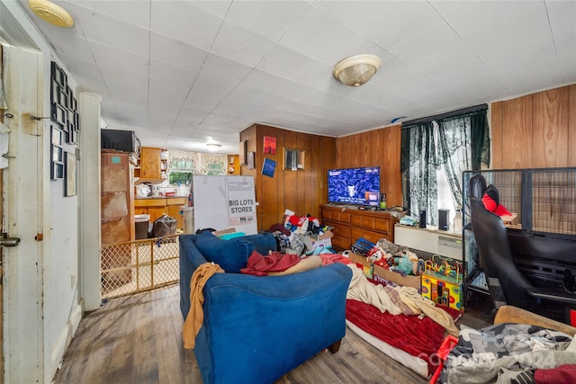 living room with wooden walls and wood-type flooring