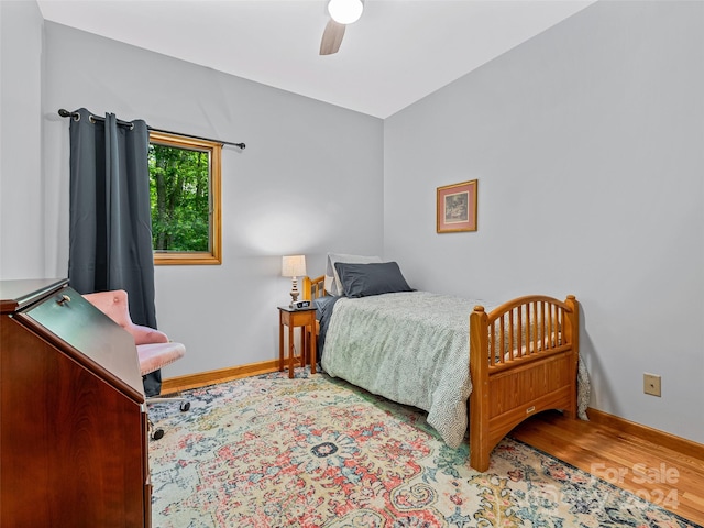 bedroom with ceiling fan and hardwood / wood-style flooring